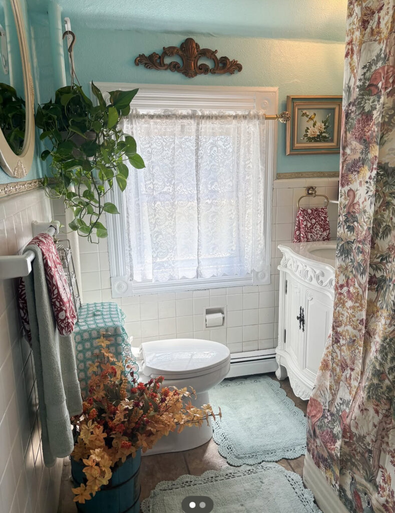 Colorful aqua space full of plants, lace, and pattern, packed with playful retro vintage bathroom ideas.