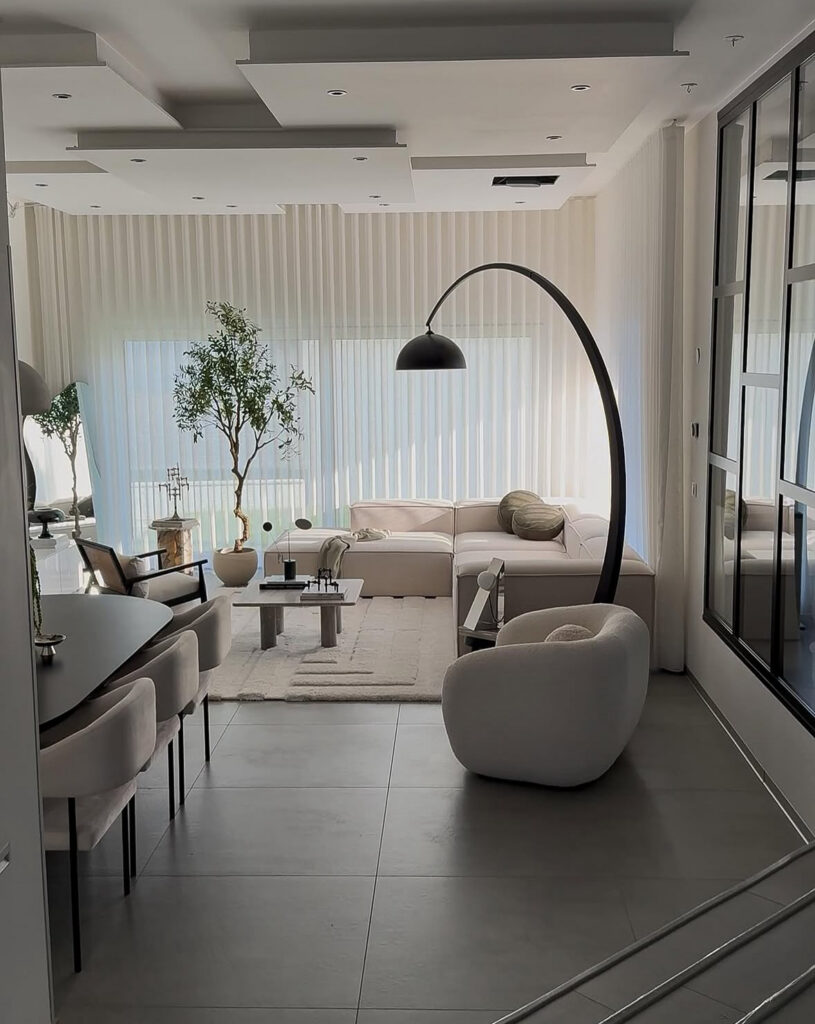 A modern minimal living room with soft neutral seating, a sculptural floor lamp and simple affordable home decor accents.