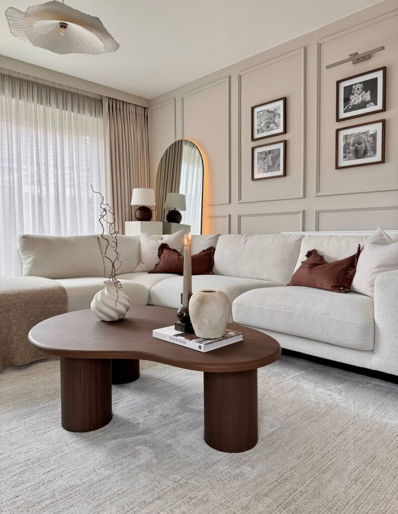 A neutral living room with warm brown pillows, sculptural vases and layered textiles showing how inexpensive decor can feel elevated.