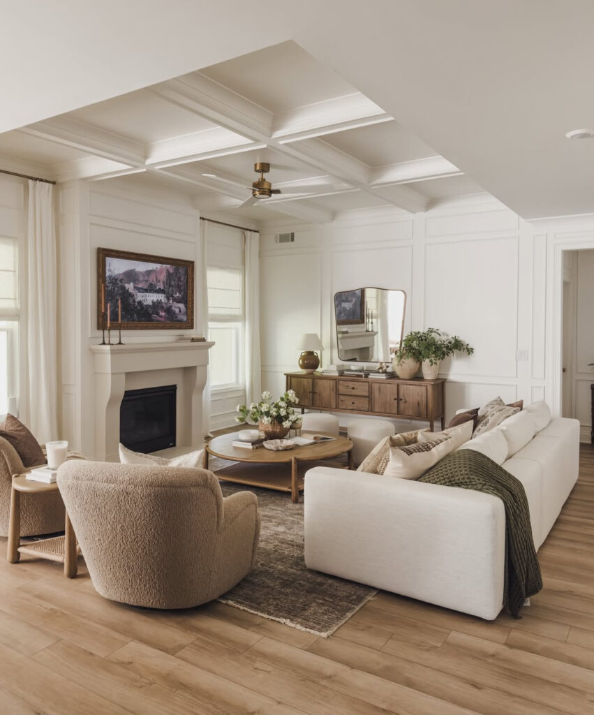 Neutral living room styled with inexpensive home decor, including a white sofa, boucle chairs and a wood coffee table for cozy living room decor on a budget.
