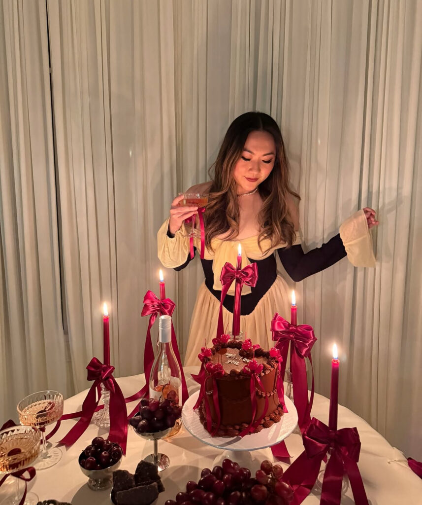 Woman in a romantic corset-style Galentine’s dinner outfit styled with candles and dessert table décor