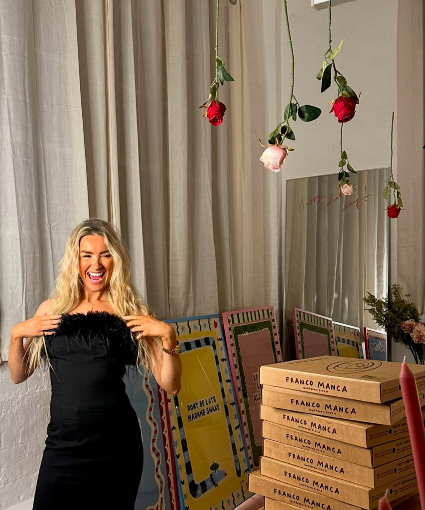 Woman in a fitted black dress styled as a dress to impress outfit for a Galentine’s party