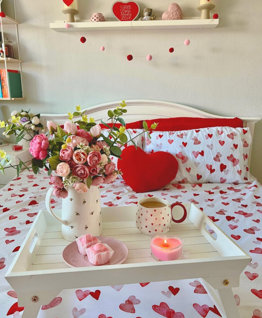 Pretty floral bedroom with pink cupcakes, candles, and heart sheets capturing cozy valentines room decor.