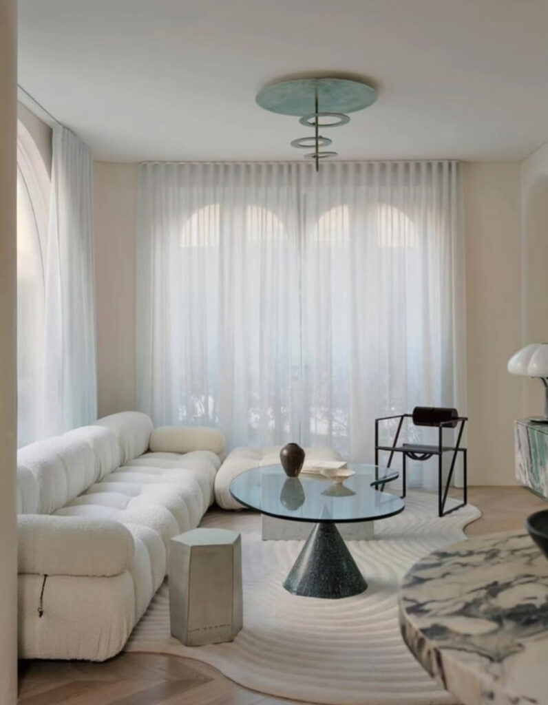 Soft minimalist apartment with sheer curtains filtering natural light into a neutral room.
