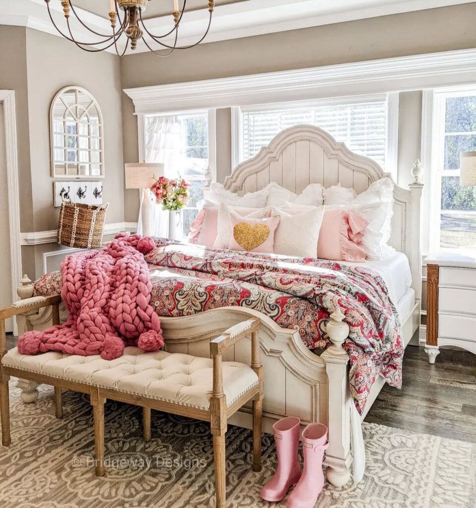 Bright sunlit bedroom with white furniture, pink pillows, and chunky blanket as romantic bedroom ideas for valentines day.
