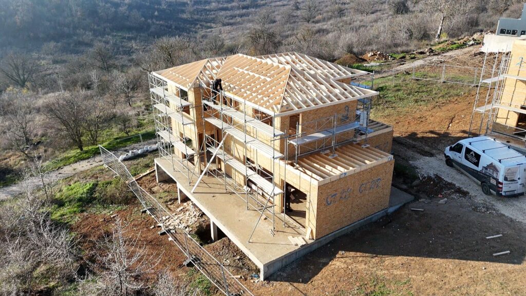 Side angle of timber frame roof framing with lower roof sections still open for later build-up