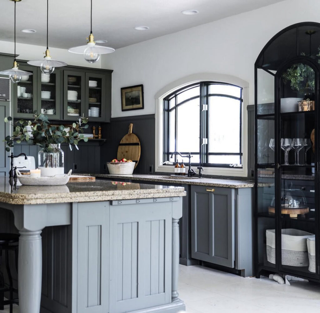 Modern cottage kitchen with deep grey cabinets, paneled island, arched window and a dark display hutch designed by @chrislovesjulia.