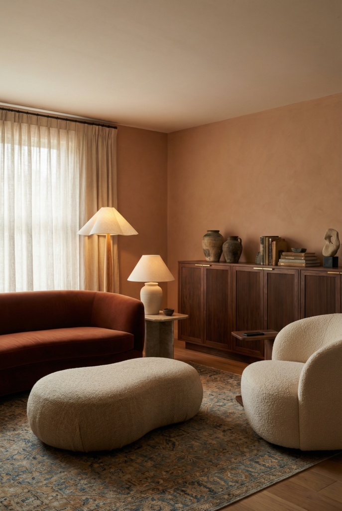 Curved silhouettes and sculptural furniture in creamy boucle, paired with natural materials for livable luxury and interior design trends.