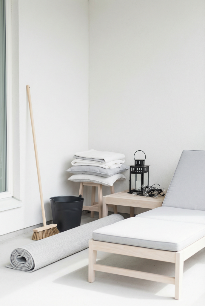 One-weekend patio refresh plan scene with budget outdoor furniture upgrades—cleaning, rug, pillows, and lights ready to style.