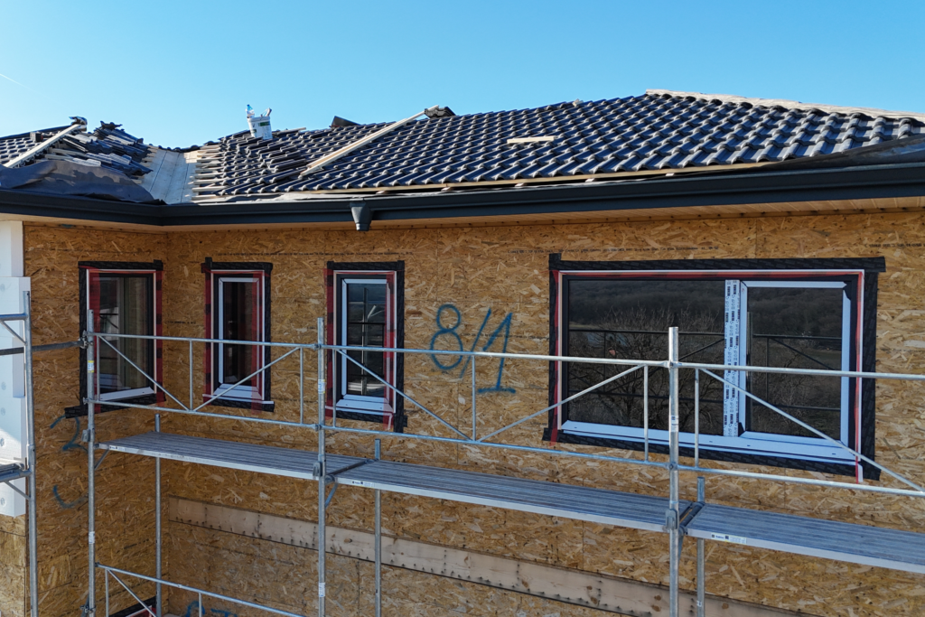 Exterior wall with newly installed windows and visible airtight tape detail before facade finish