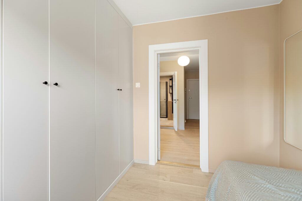 Modern built-in wardrobe with minimal hinged doors and black hardware