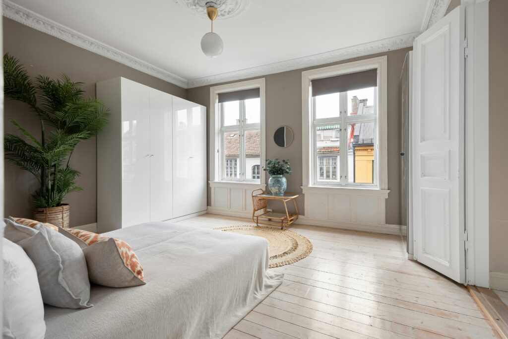 White freestanding wardrobe in classic bedroom with crown molding and period features