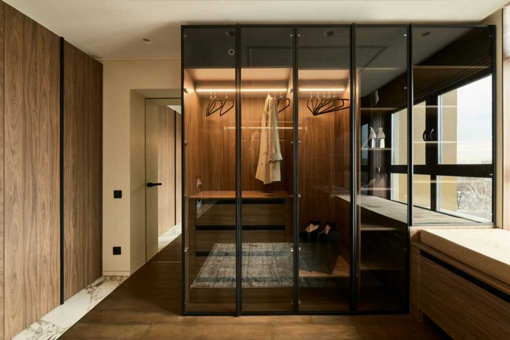 Walk in closet with built-in storage glass doors and integrated LED lighting