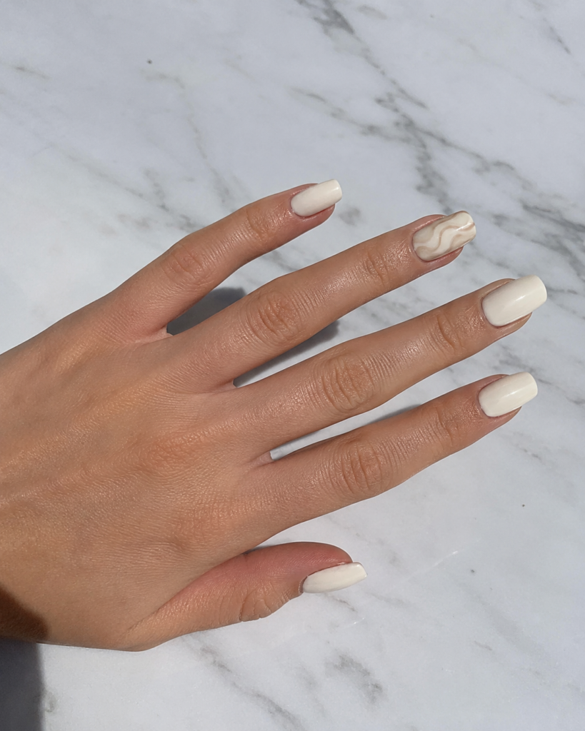 Cream nails with beige abstract swirl design on accent nail