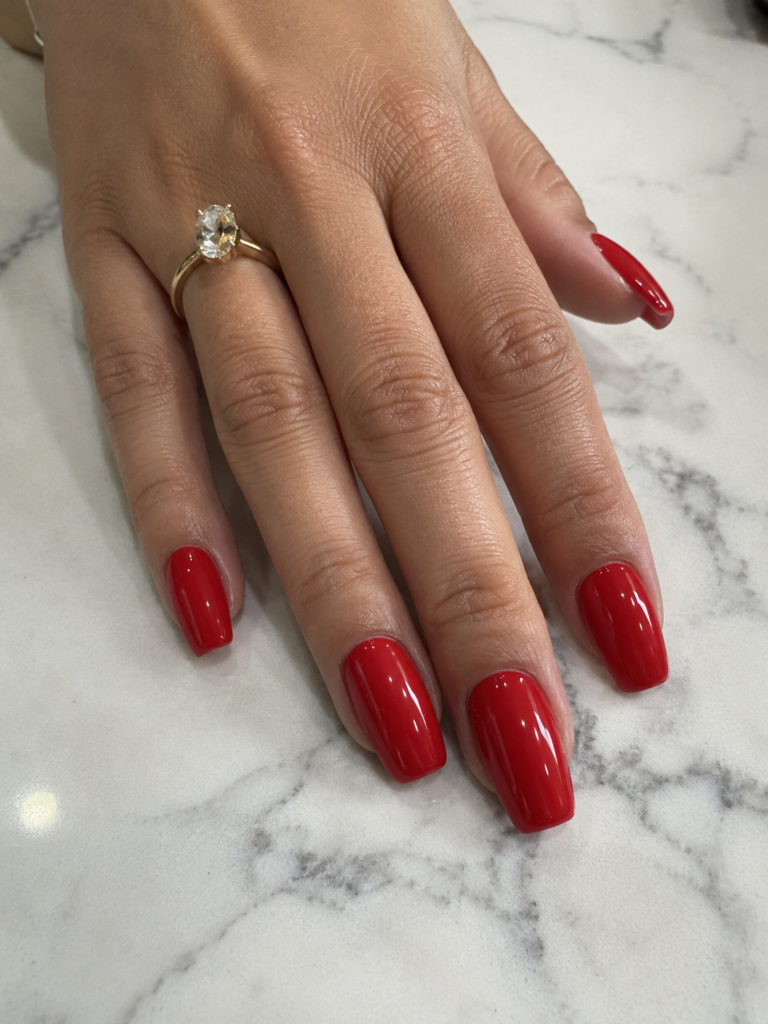 Bright cherry red high gloss nails on coffin shaped gel manicure