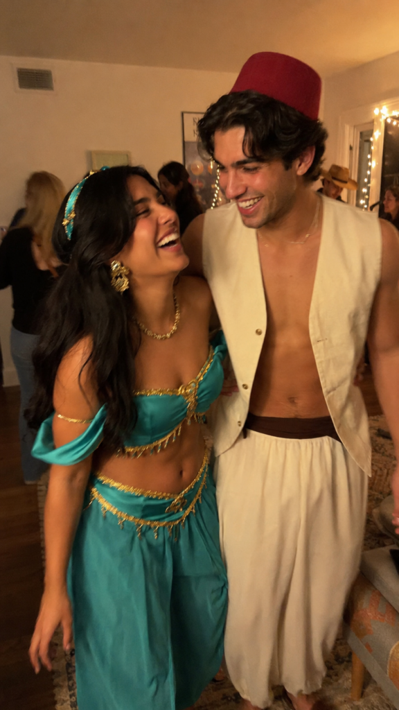 Couple in jewel-toned teal and cream costumes with gold jewelry, Aladdin and Jasmine Disney Halloween costume