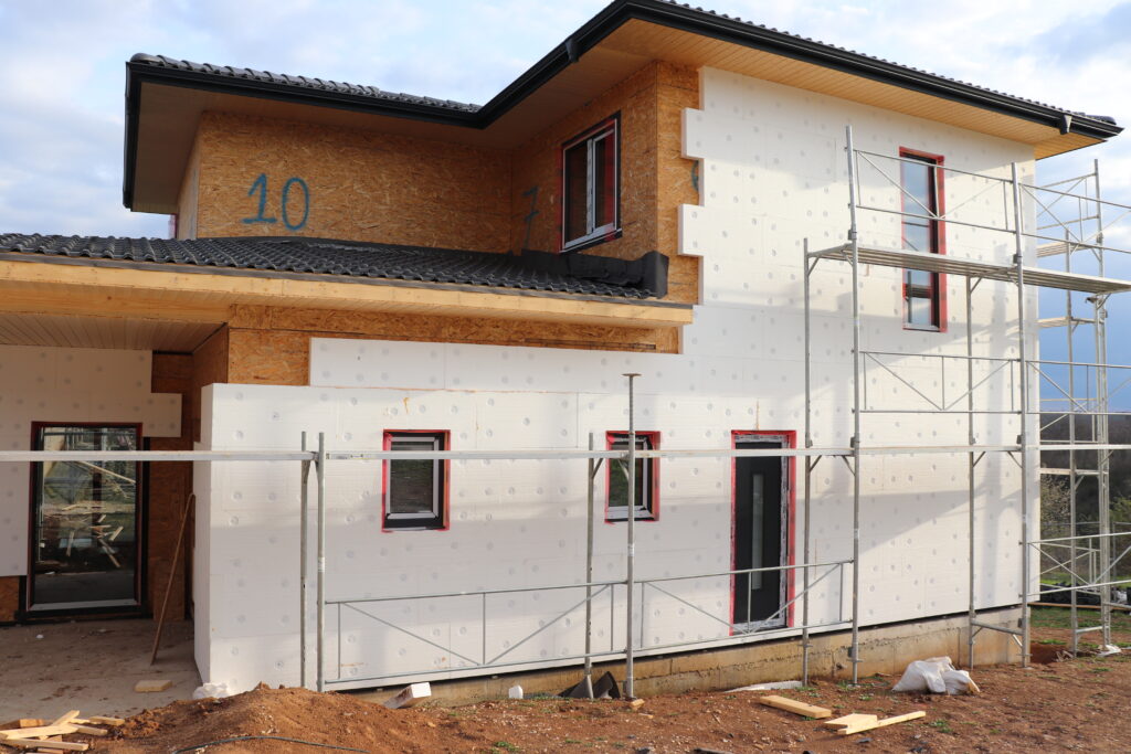 White EPS insulation installed over a timber frame house before the warm white exterior finish