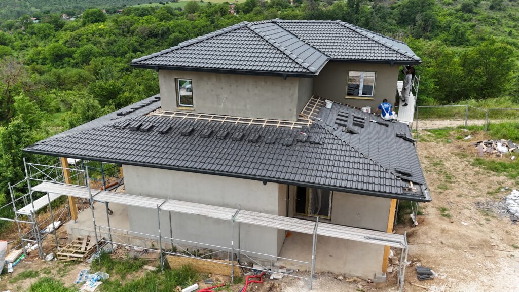 Workers applying exterior base coat before the warm white exterior finish